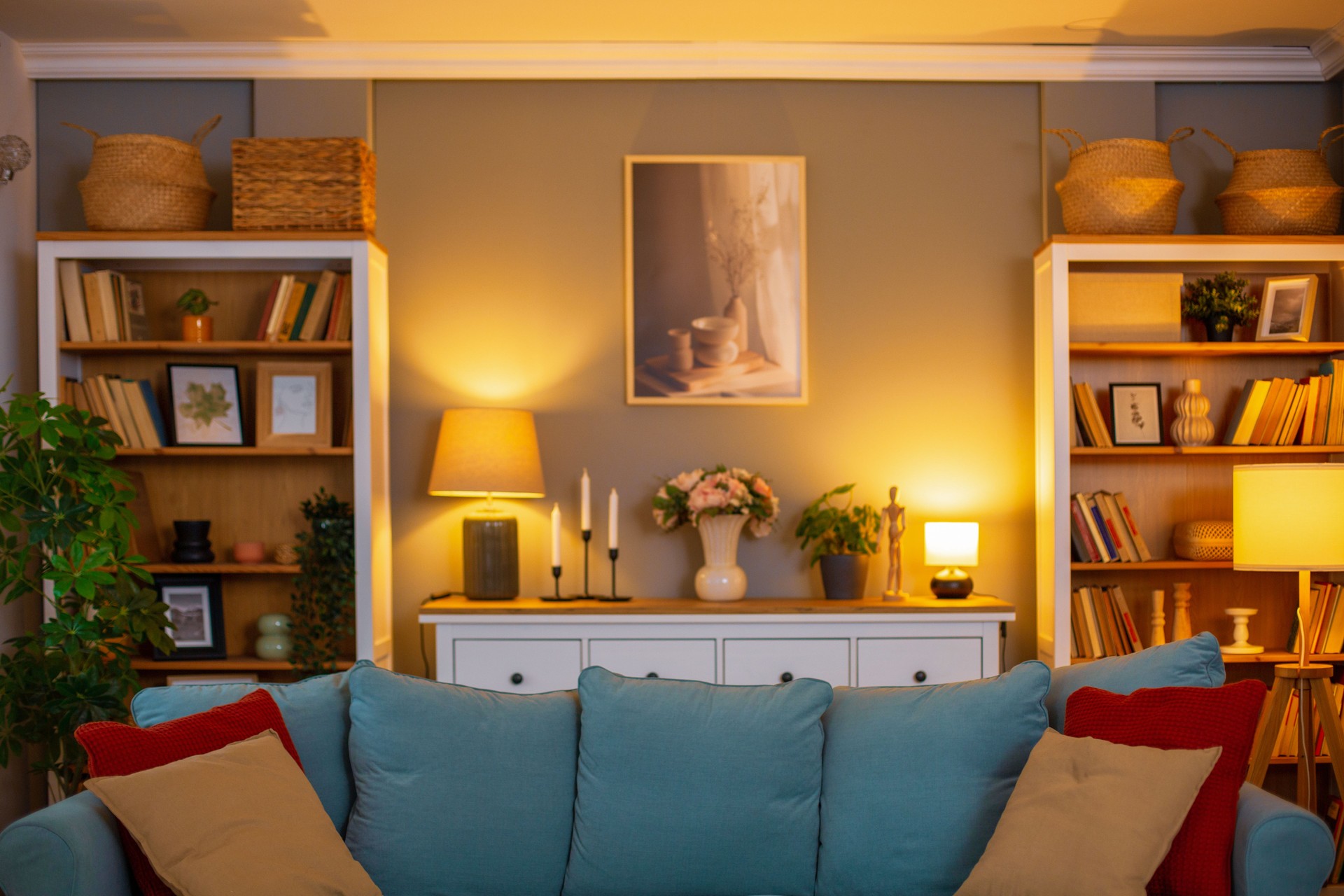 Cozy living room interior with sofa, bookshelves, and warm lighting